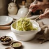 Hands scooping out greek cabbage salad with serving spoons